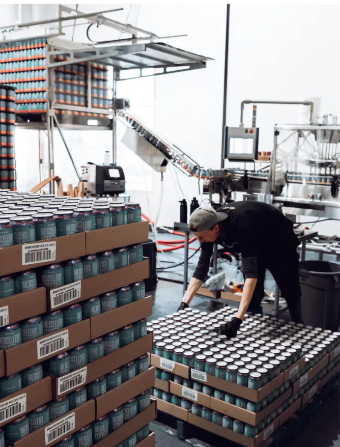 a worker stacking pallets of beer